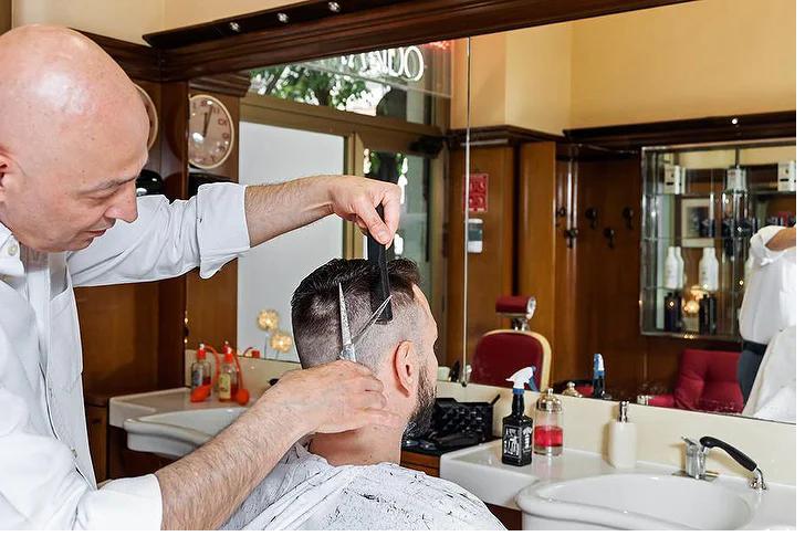 Interno della barberia con arredi in legno, specchi e poltrone originali vintage